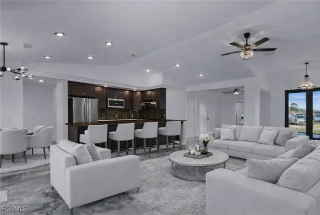 a living room with furniture and a view of kitchen