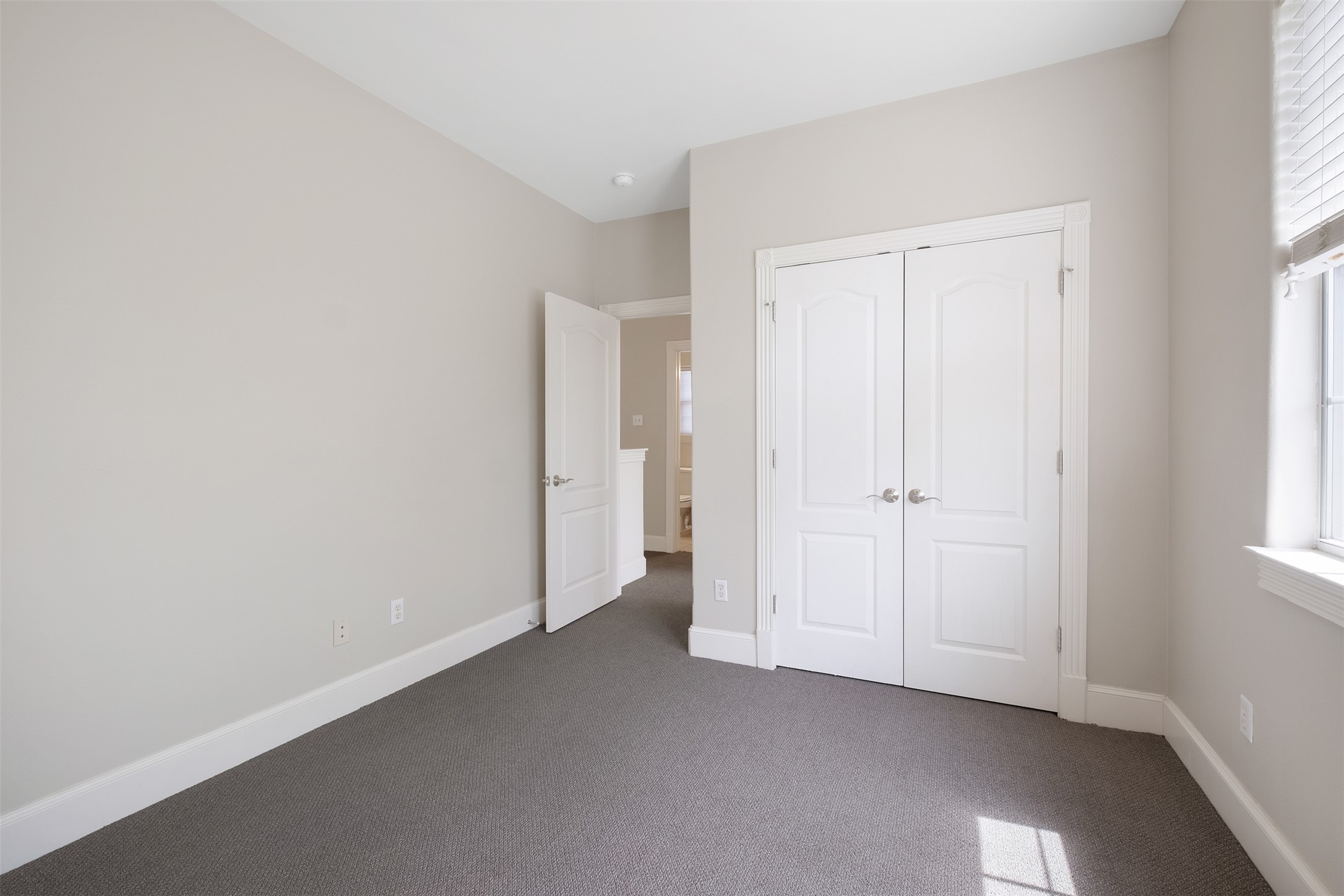 6715 Windrift Way, Unit 8 Austin, TX 78745 - Photo 22 of 24 An inviting room boasts soft gray carpeting, a bright window, and convenient double-door closets.