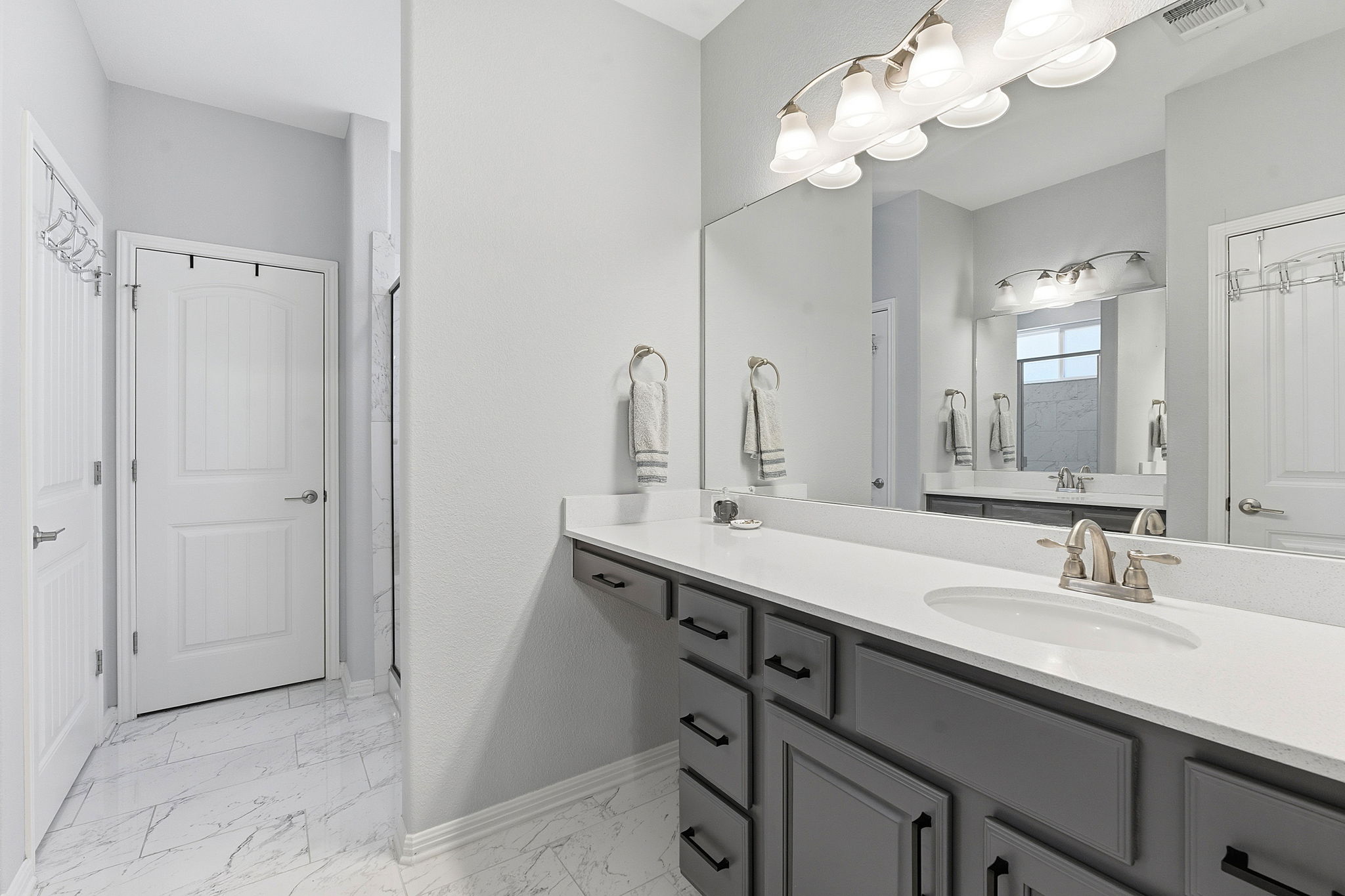 5720 Baythorne Drive Austin, TX 78747 - Photo 15 of 19 a bathroom with a double vanity sink and a mirror