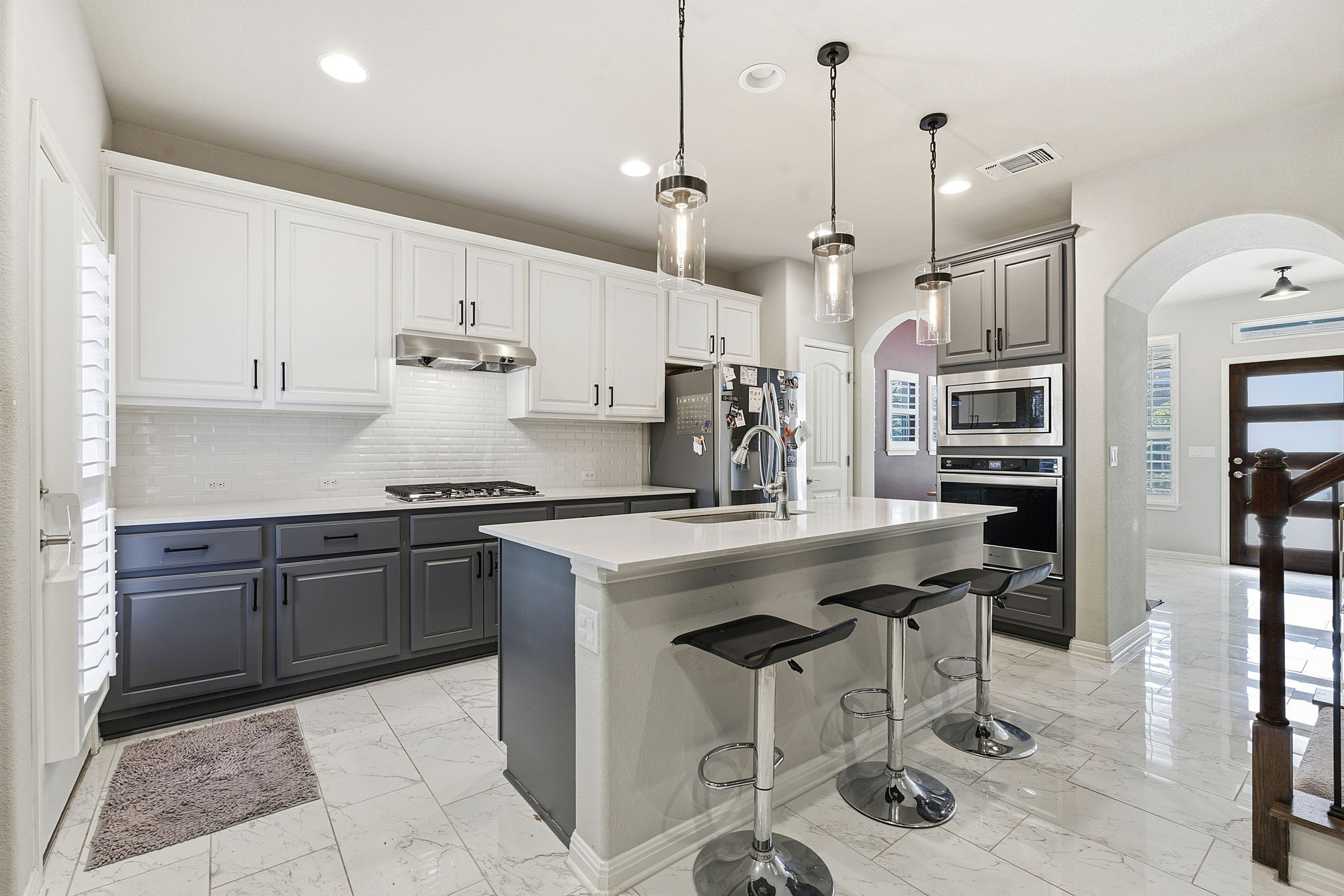 5720 Baythorne Drive Austin, TX 78747 - Photo 5 of 19 a kitchen with stainless steel appliances granite countertop a sink a stove a refrigerator and island with wooden floor