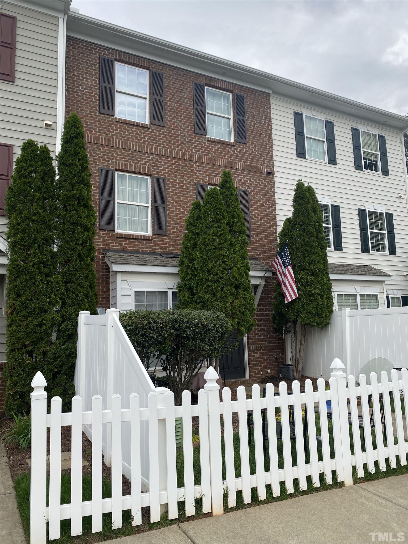 1121 Consortium Drive, Unit 106 Raleigh, NC 27603 - Photo 1 of 22 a front view of white house with a garden