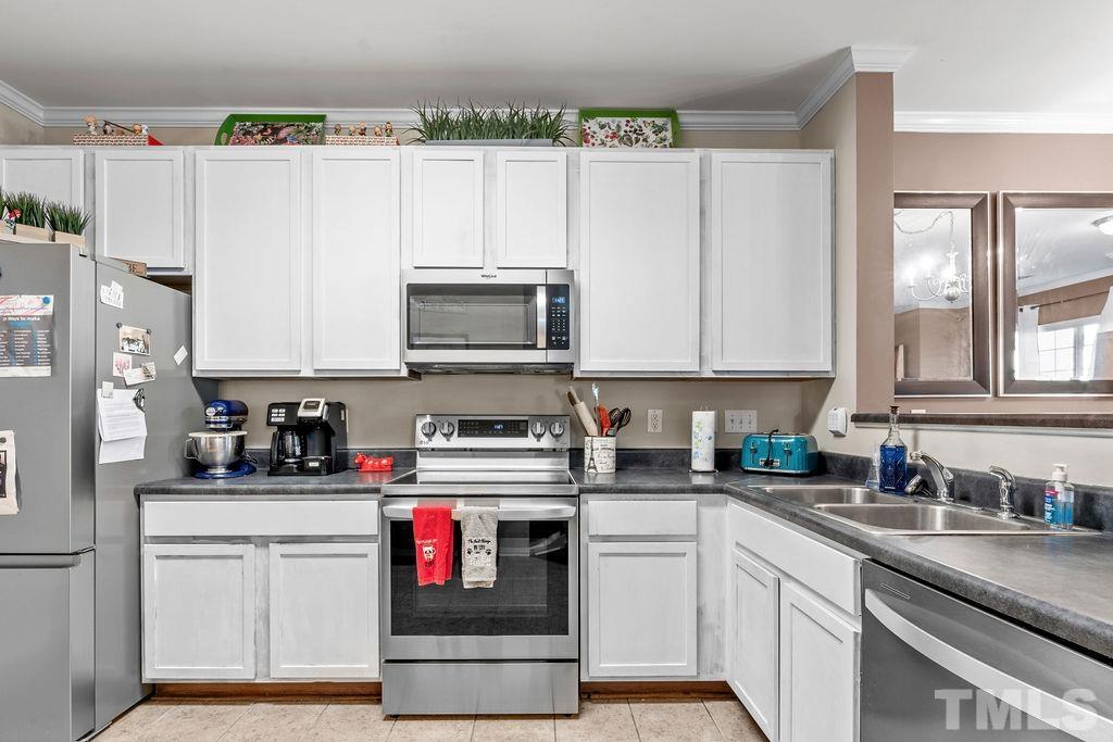 1121 Consortium Drive, Unit 106 Raleigh, NC 27603 - Photo 10 of 22 a kitchen with stainless steel appliances granite countertop a stove a sink and a white cabinets