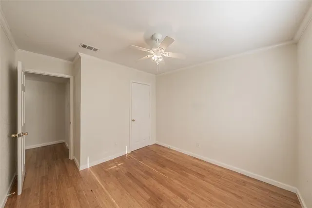 a view of empty room with wooden floor and ceiling fan