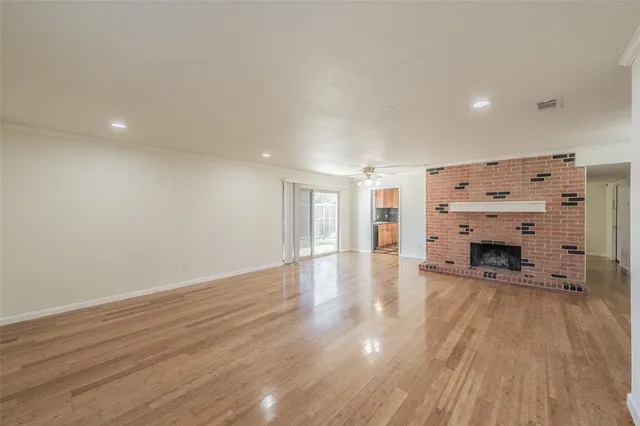 a view of a livingroom with a fireplace a chandelier and wooden floor