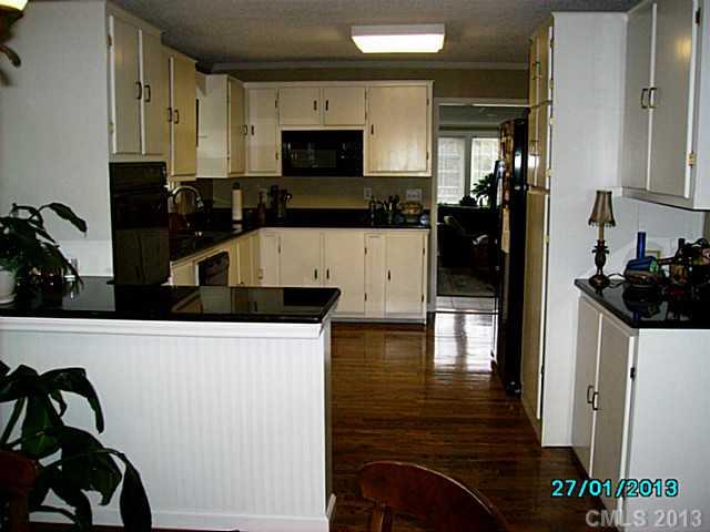 7680 Stokes Ferry Road Salisbury, NC 28146 - Photo 4 of 16 a kitchen with stainless steel appliances a stove a sink and a refrigerator