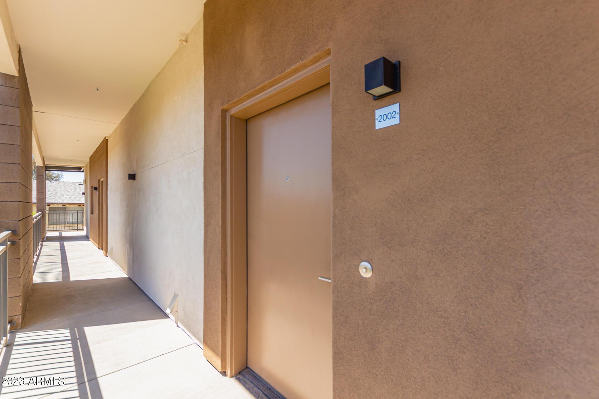 2063 East Lemon Street, Unit 2003 Tempe, AZ 85281 - Photo 2 of 6 a view of a hallway with wooden floor and a living room