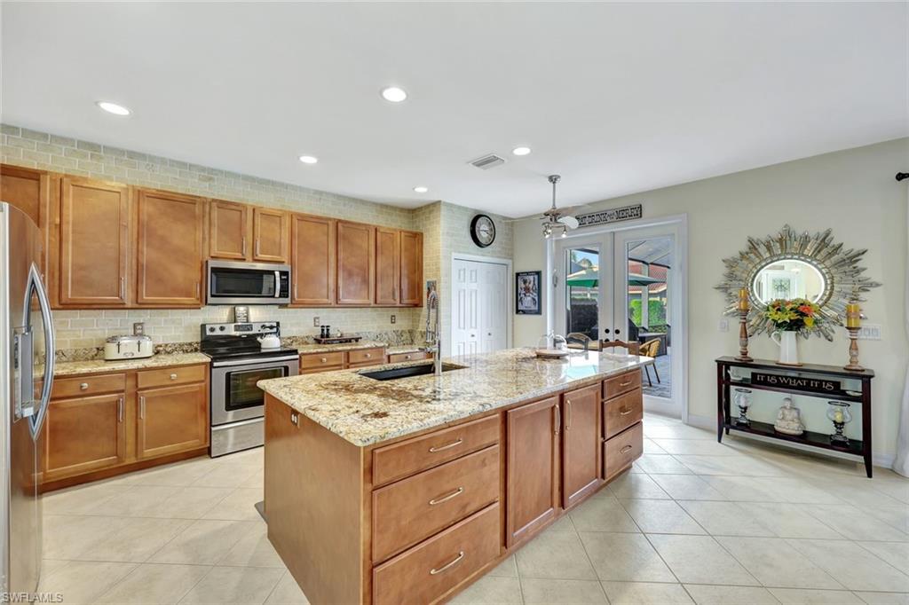 1614 Triangle Palm Terrace Naples, FL 34119 - Photo 7 of 40 a kitchen with a stove top oven sink and cabinets