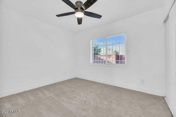 1734 East Laguna Drive Tempe, AZ 85282 - Photo 11 of 23 an empty room with a window and a fan