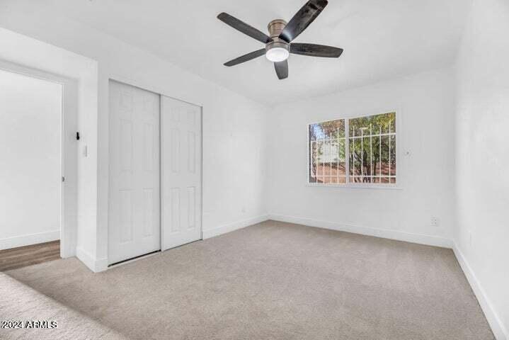 1734 East Laguna Drive Tempe, AZ 85282 - Photo 12 of 23 an empty room with a ceiling fan and windows