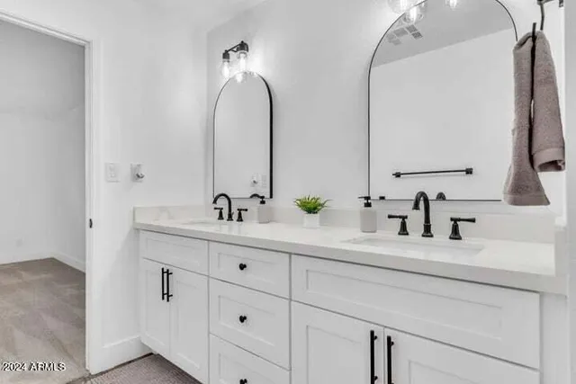 a bathroom with double vanity sink and a mirror
