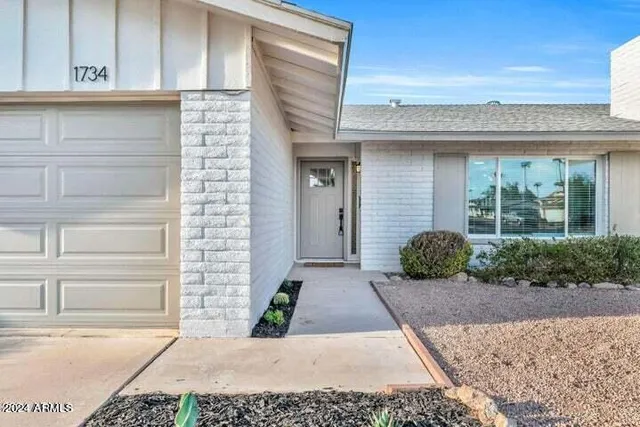 a front view of a house with a garden