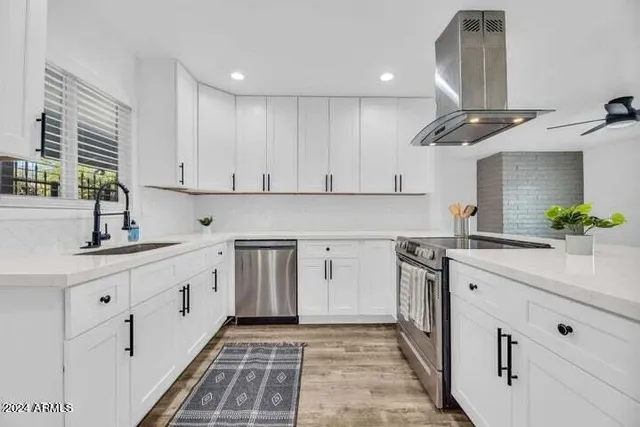 a kitchen with cabinets appliances a sink and a counter top space