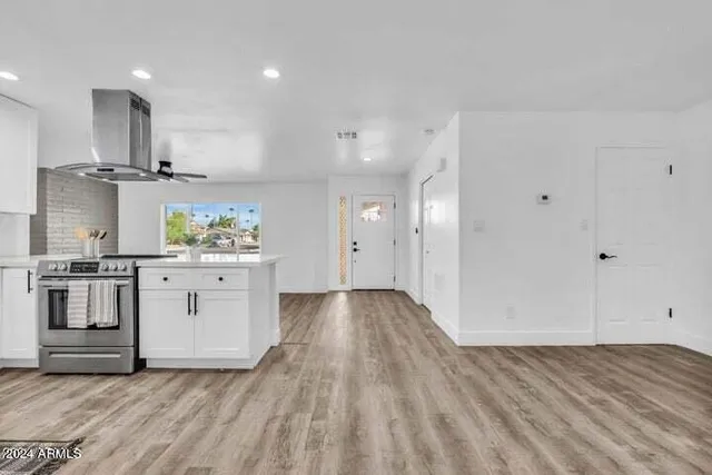 a kitchen with white cabinets and stainless steel appliances
