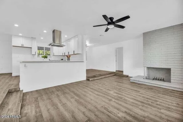 a kitchen with stainless steel appliances kitchen island a refrigerator sink and white cabinets