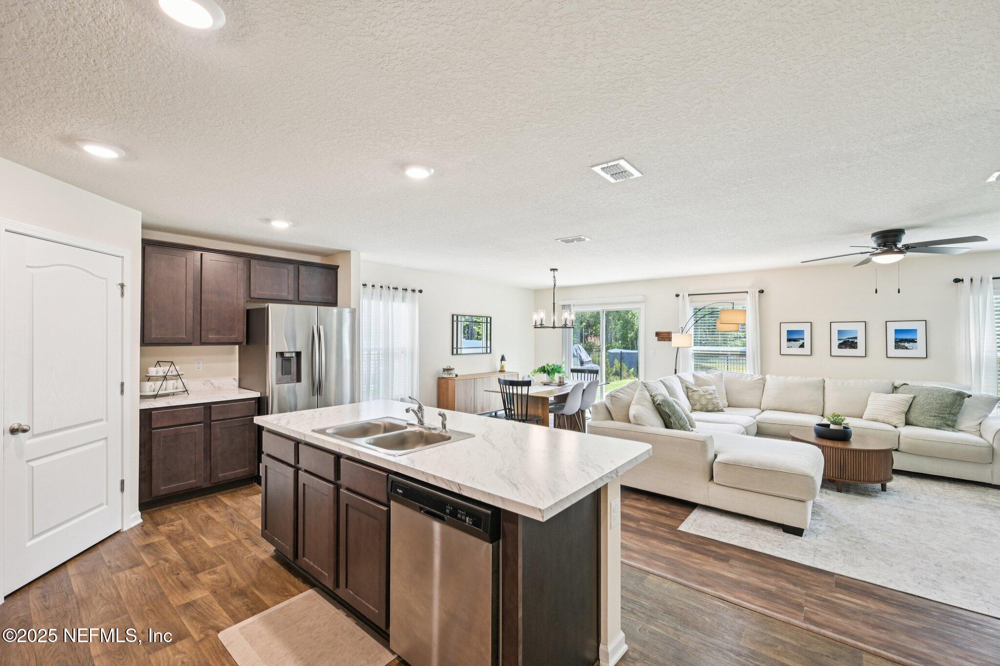 1143 Morgans Treasure Road St. Augustine, FL 32084 - Photo 11 of 39 a large living room with stainless steel appliances granite countertop a couch and a view of kitchen