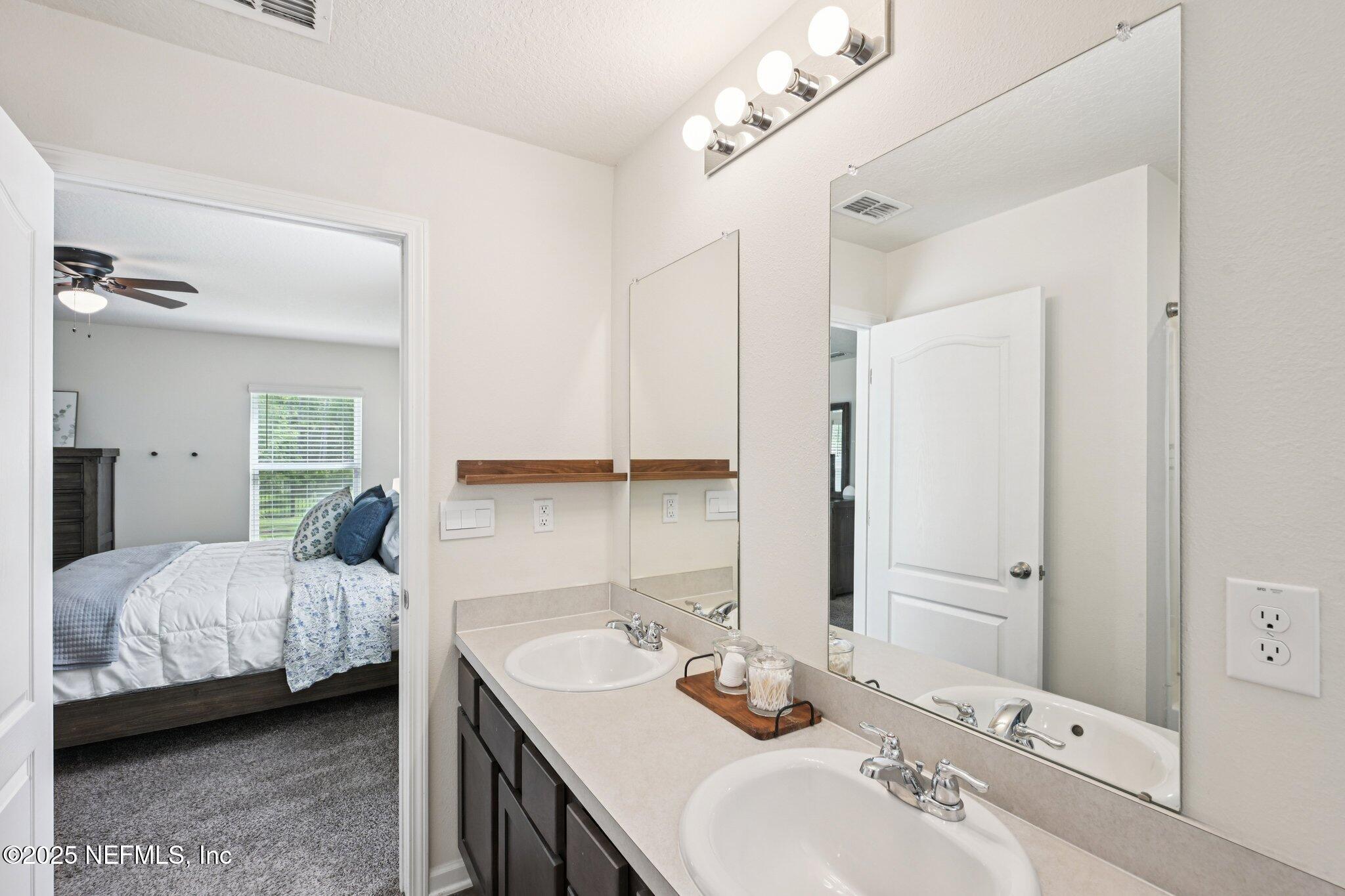 1143 Morgans Treasure Road St. Augustine, FL 32084 - Photo 30 of 39 a bedroom with a bed and a mirror