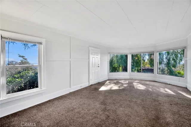 a view of a big room with windows and front door