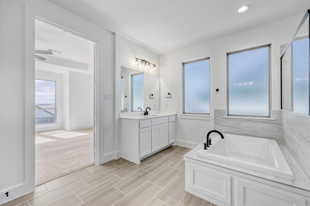 147 Derrett Lane Rhome, TX 76078 - Photo 16 of 28 Full bath with a bath, vanity, healthy amount of natural light, and wood finish floors