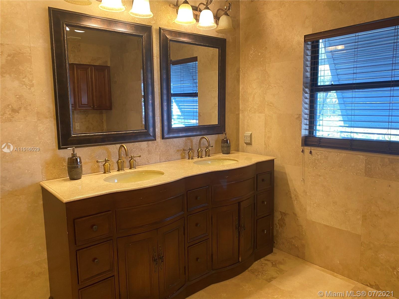 5278 Boca Marina Circle South Boca Raton, FL 33487 - Photo 15 of 37 a bathroom with a double vanity sink and a mirror