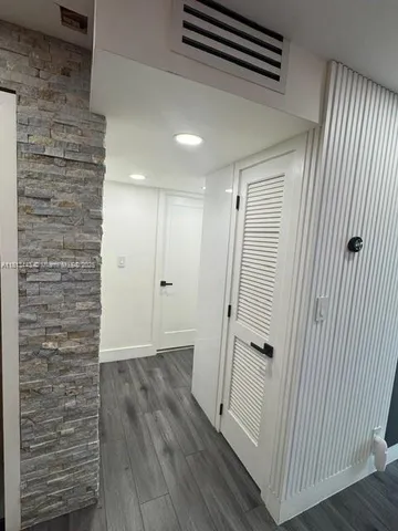 a bed sitting in a kitchen with wooden floors