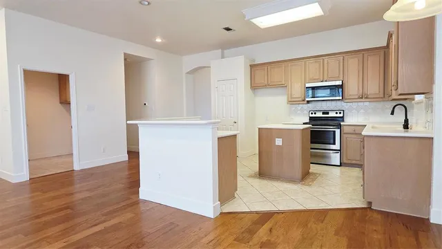 a kitchen with stainless steel appliances granite countertop a refrigerator a stove top oven a sink and dishwasher