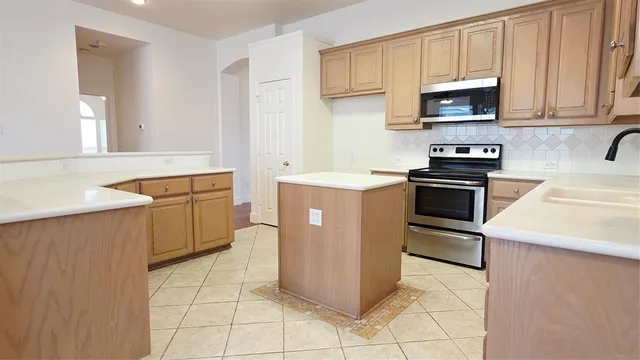 a kitchen with stainless steel appliances a stove sink and cabinets