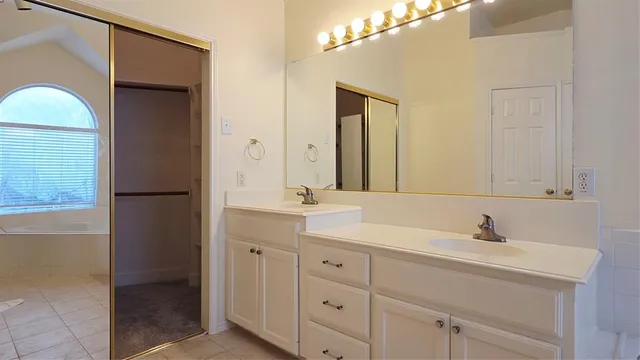 a bathroom with a double vanity sink and a mirror