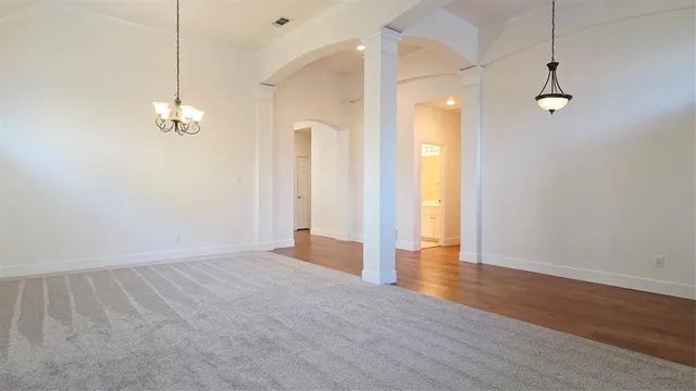 a view of a room with wooden floor and a ceiling fan