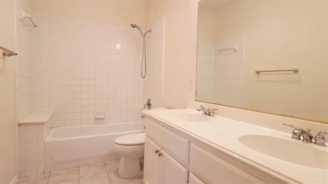 a bathroom with a granite countertop sink a toilet and shower