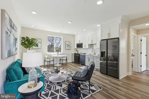 a dining room with furniture and a kitchen view