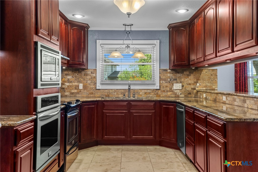 3745-3735 Canyon Heights Road Belton, TX 76513 - Photo 14 of 45 a kitchen with stainless steel appliances granite countertop a stove sink and cabinets