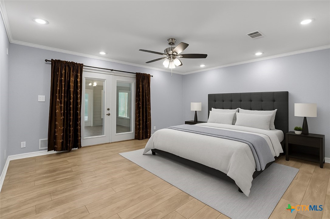 3745-3735 Canyon Heights Road Belton, TX 76513 - Photo 27 of 45 a bedroom with a large bed and a chandelier