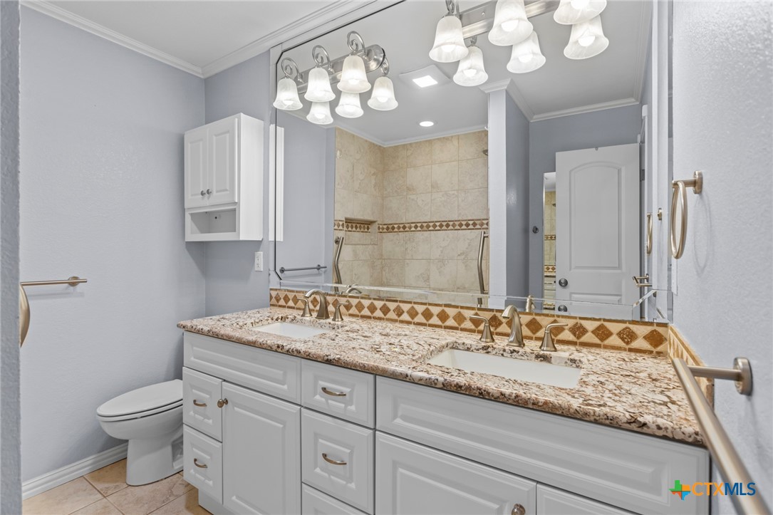 3745-3735 Canyon Heights Road Belton, TX 76513 - Photo 35 of 45 a bathroom with a granite countertop sink a toilet and a mirror