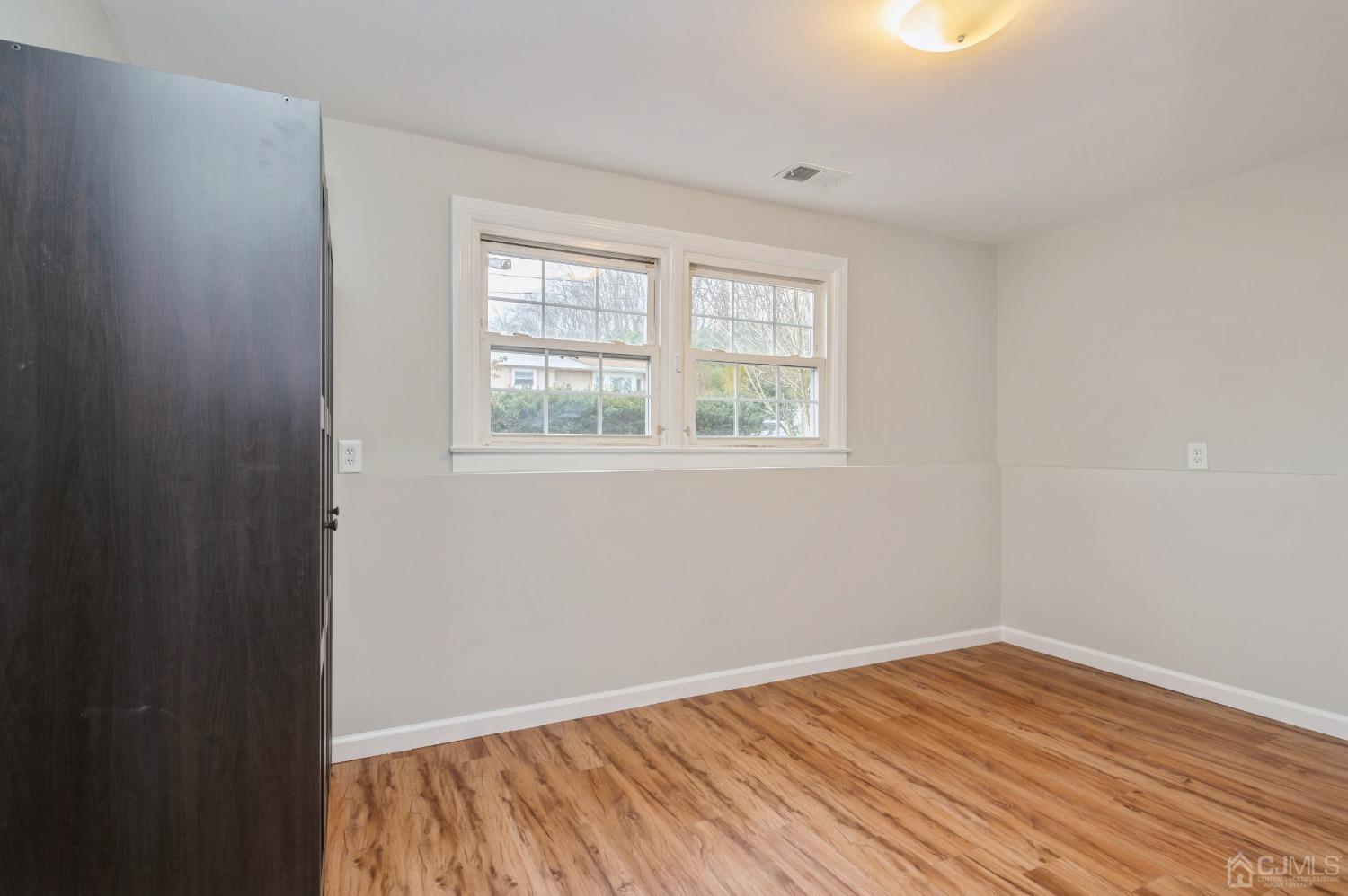 1 Bruce Road East Brunswick, NJ 08816 - Photo 16 of 21 an empty room with wooden floor and windows
