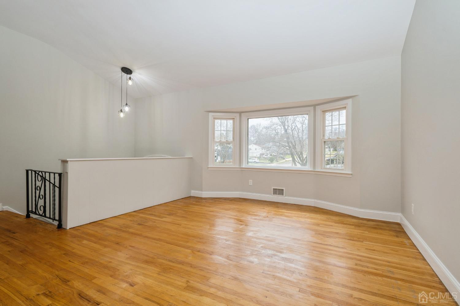 1 Bruce Road East Brunswick, NJ 08816 - Photo 4 of 21 a view of empty room with wooden floor and fan