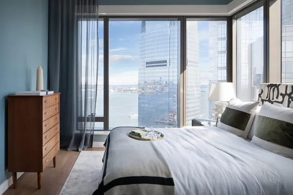 a bedroom with a bed and a flat tv screen next to a large window