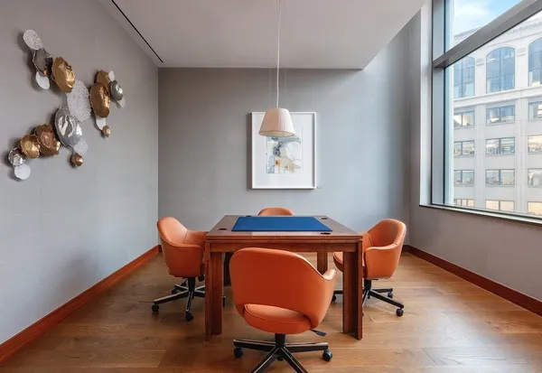 a view of a workspace with furniture and a window