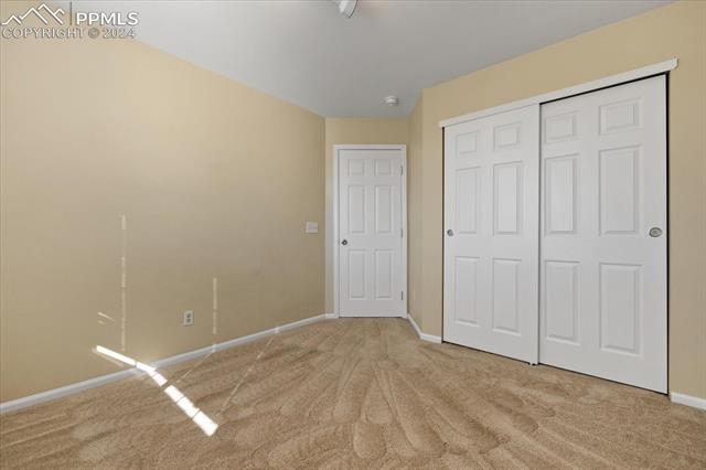7655 Coffee Road Peyton, CO 80831 - Photo 17 of 31 Unfurnished bedroom featuring light carpet and a closet