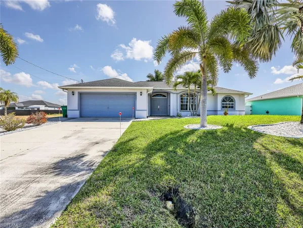 a view of a house with a big yard and palm trees