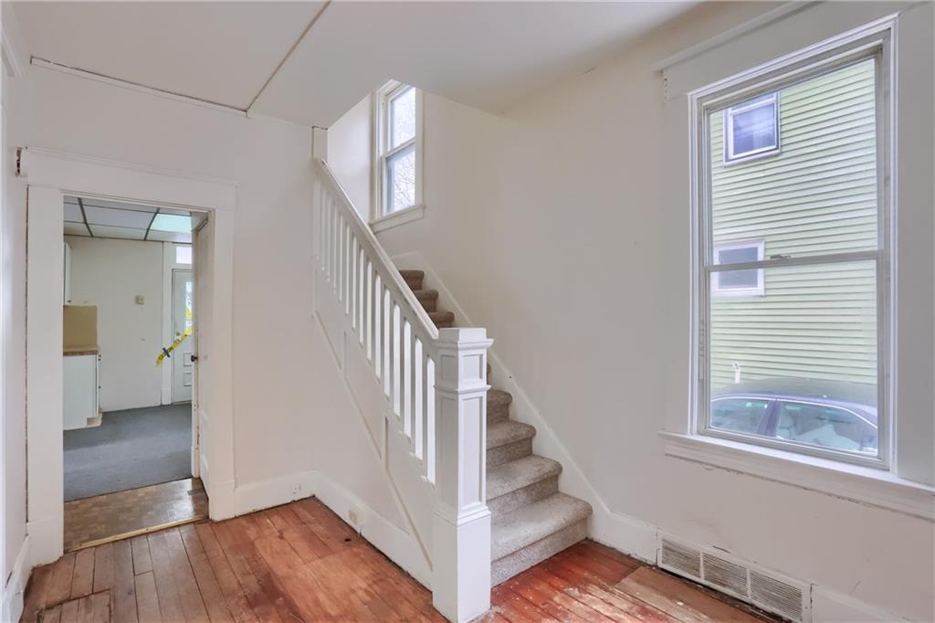 Bright windows flood the wooden staircase.