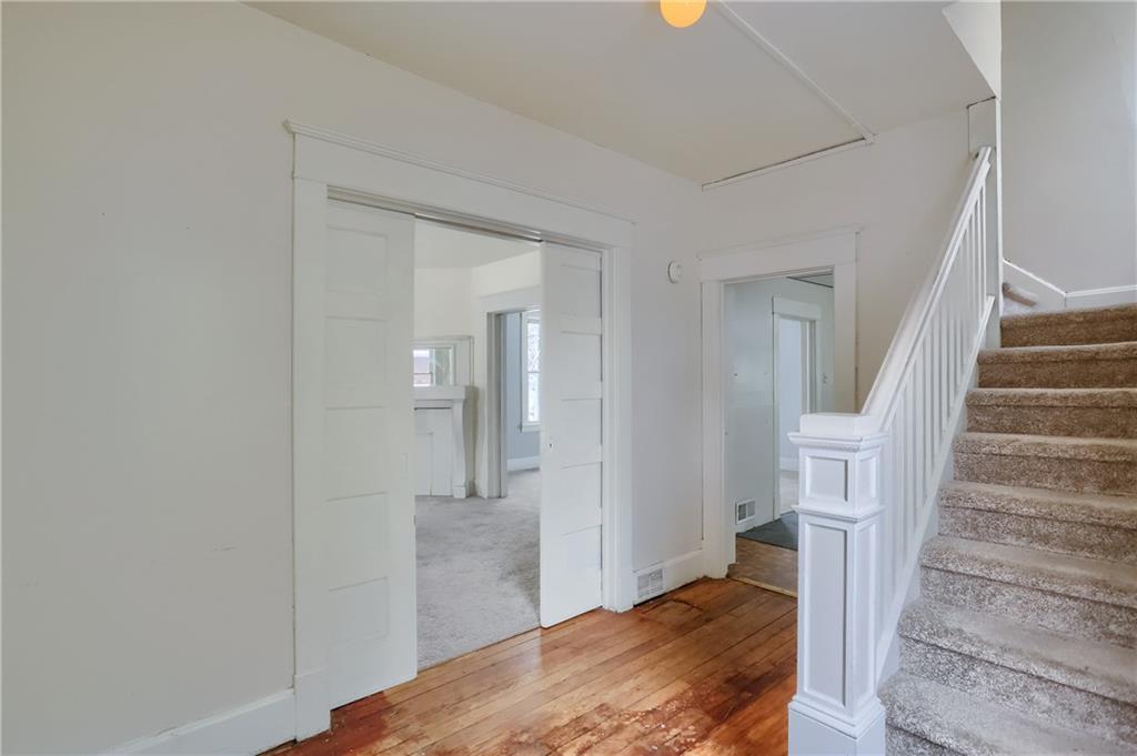 Enter into a spacious foyer with hardwood and beautiful pocket doors.