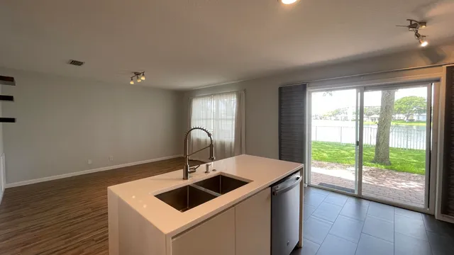 a kitchen with a sink and a stove top oven with wooden floor