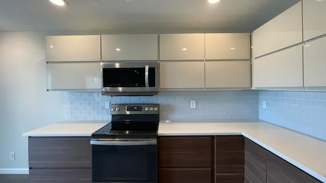 a kitchen with stainless steel appliances a refrigerator sink and microwave