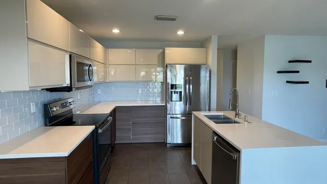 a kitchen with stainless steel appliances a refrigerator sink and microwave
