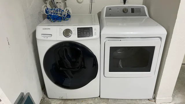 a kitchen with stainless steel appliances granite countertop a refrigerator a sink dishwasher a stove and white countertops with wooden floor