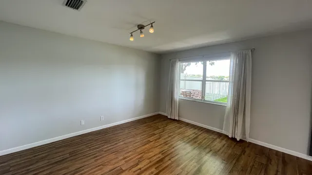 a view of an empty room with wooden floor