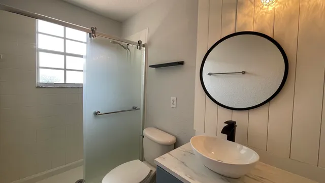 a bathroom with a sink toilet tub vanity and shower