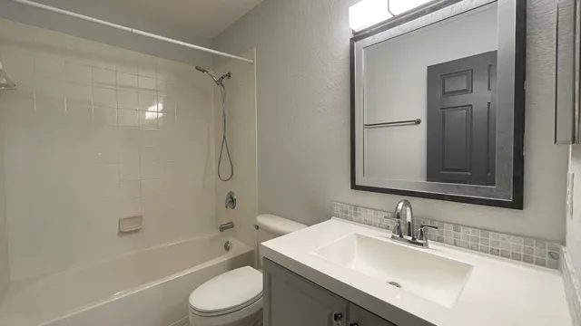 a bathroom with a sink toilet and mirror