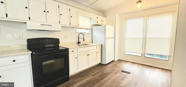 a kitchen with granite countertop white cabinets and black appliances