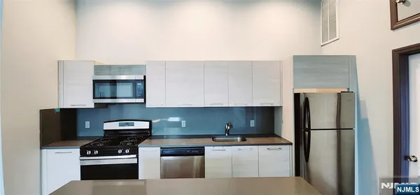 a kitchen with stainless steel appliances a refrigerator stove and microwave